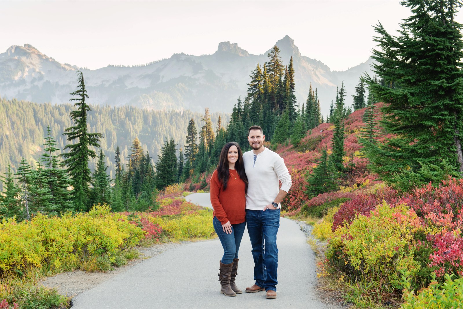 Rob and Emily, the owners of Pacific Northwest Couriers, standing together on a trail below Mount Rainier